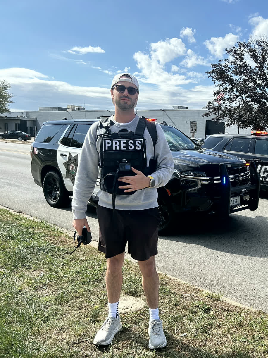 David Khait reporting in a press vest on assignment